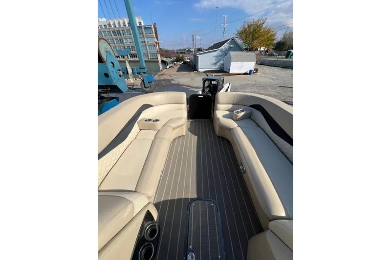 Slide: The Image of 2020 Manitou Oasis 250 pontoon boat with beige seating and spacious deck. - 9
