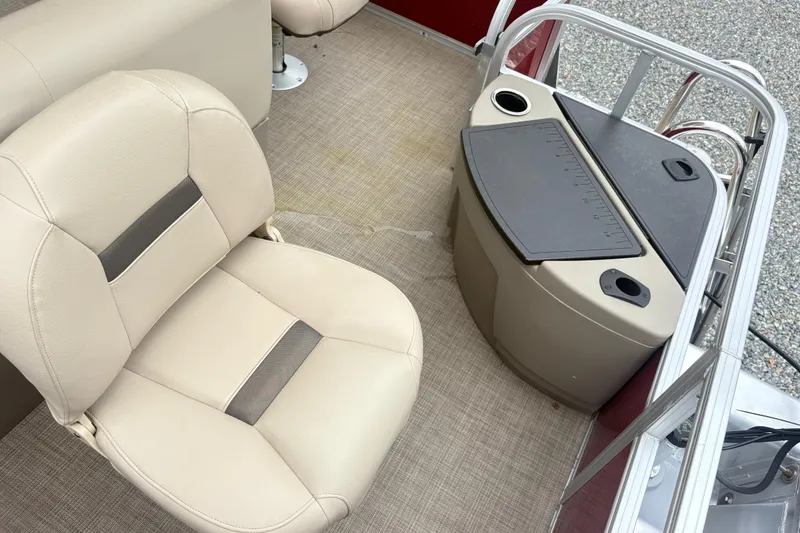 Slide: The Image of 2025 Sun Tracker Bass Buggy 18 DLX interior with beige seating and fishing station. - 14