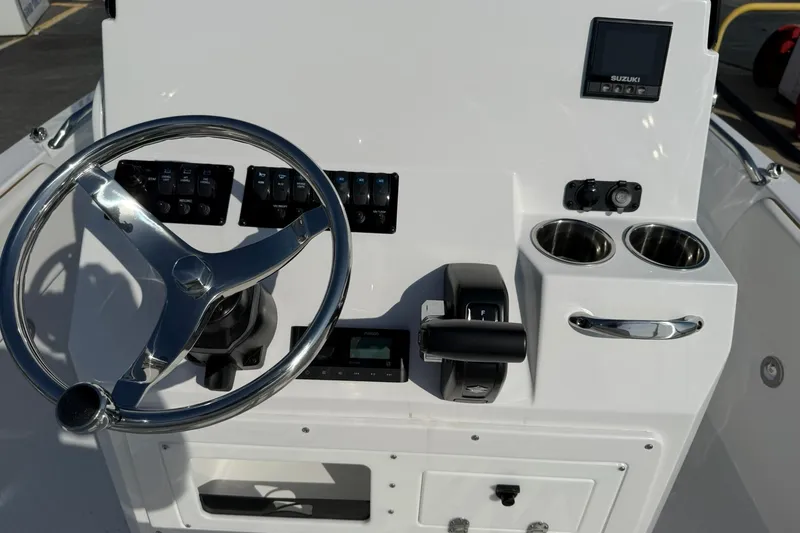 Slide: The Image of 2026 Stingray 173 CC boat console with steering wheel, controls, and cup holders. - 12