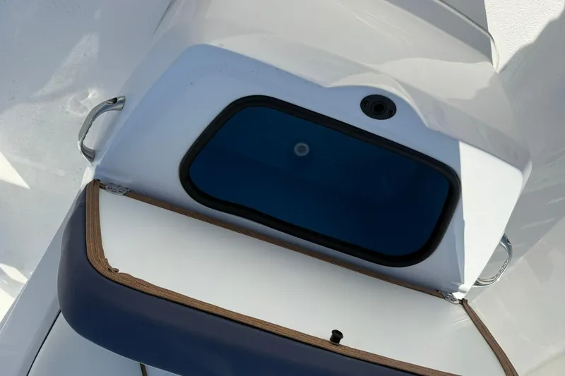 Slide: The Image of Open storage compartment on 2026 Stingray 173 CC boat, featuring sleek design and blue interior. - 16