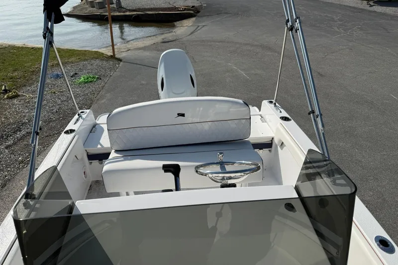 Slide: The Image of 2026 Stingray 173 CC boat interior with steering wheel and seating, near water. - 19