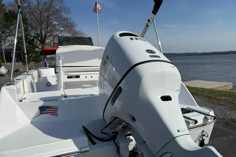 Slide: The Image of 2026 Stingray 173 CC boat with outboard motor, docked by a serene lake. - 3