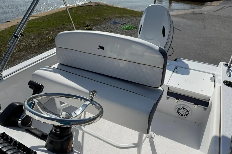 Slide: The Image of 2026 Stingray 173 CC boat interior with steering wheel and seating near water. - 9