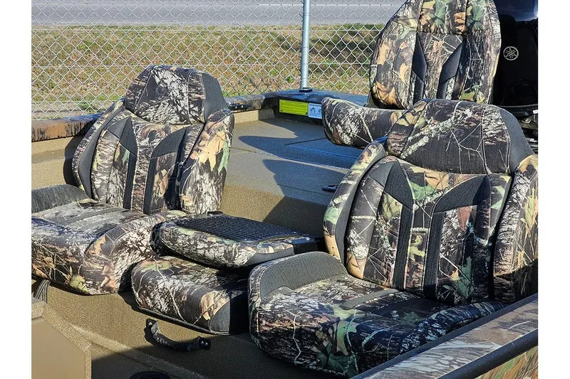 Slide: The Image of 2026 G3 Sportsman 1810 boat seats with camouflage upholstery, set against a chain-link fence. - 11
