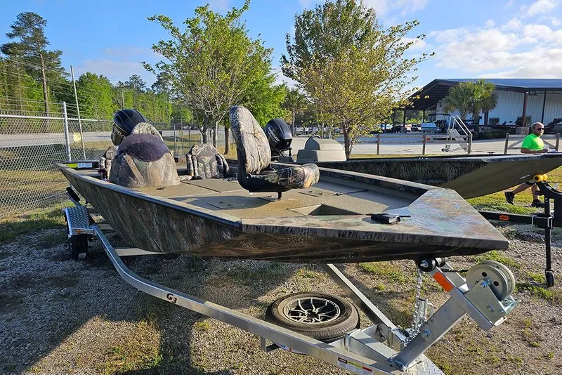 Slide: The Image of 2026 G3 Sportsman 1810 boat on trailer, parked outdoors near trees and a building. - 3