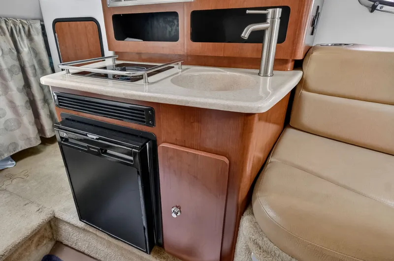 Slide: The Image of Interior of 2019 Crownline 264 CR with kitchenette and seating area. - 13