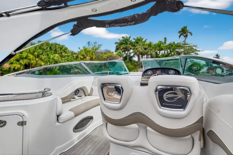 Slide: The Image of Interior of a 2019 Crownline 264 CR boat with palm trees in the background. - 23