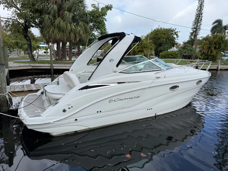 Slide: The Image of 2019 Crownline 264 CR boat docked, surrounded by trees. - 3