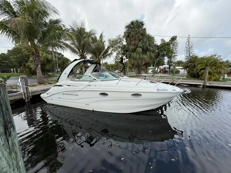 Slide: The Image of 2019 Crownline 264 CR boat docked, surrounded by palm trees. - 4