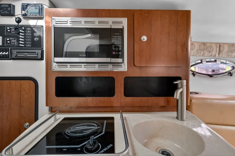 Slide: The Image of Interior of 2019 Crownline 264 CR featuring kitchen and microwave. - 9