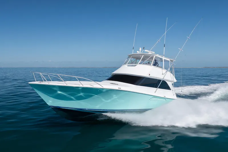 Slide: The Image of A 2000 Viking 55 Convertible yacht cruising on clear blue waters. - 13