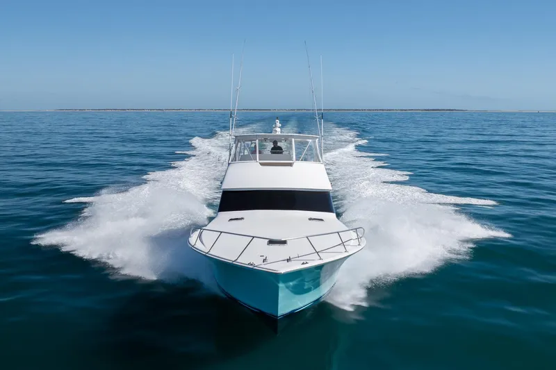 Slide: The Image of 2000 Viking 55 Convertible yacht cruising on open sea, creating a dynamic wake. - 14