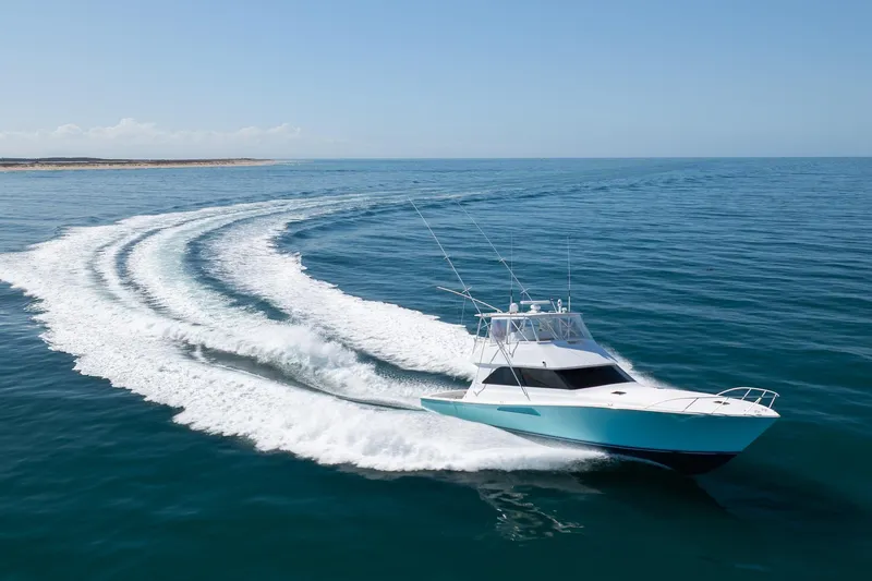 Slide: The Image of 2000 Viking 55 Convertible yacht cruising on open sea, leaving a wake trail. - 17