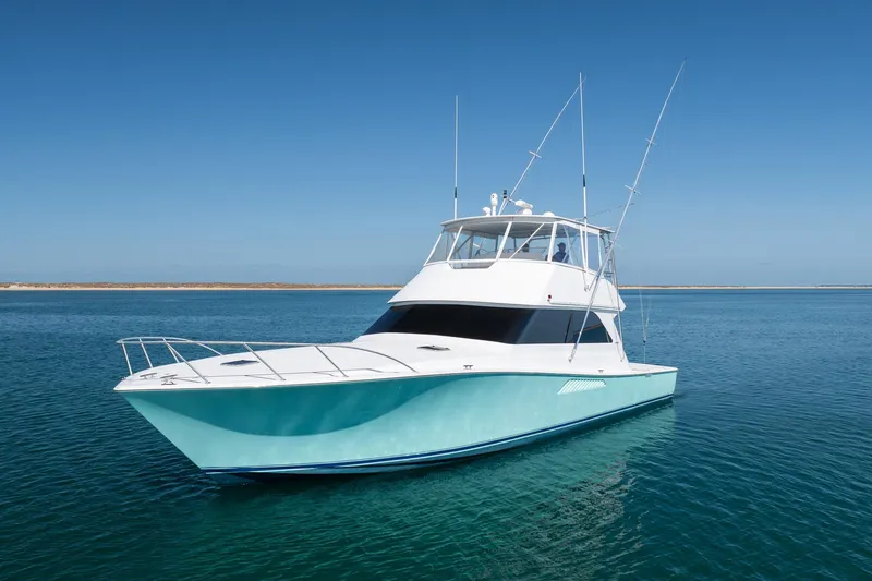 Slide: The Image of 2000 Viking 55 Convertible yacht on calm blue waters under clear sky. - 2