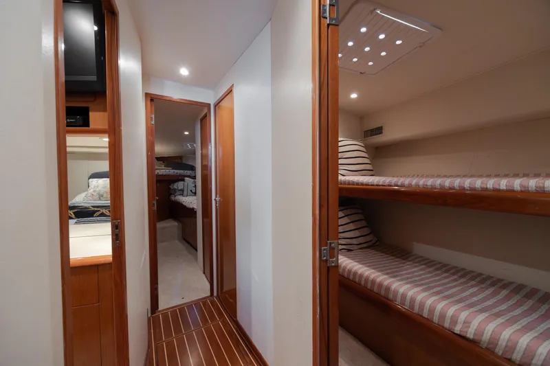 Slide: The Image of Interior of 2000 Viking 55 Convertible yacht with cozy bunk beds and wood finishes. - 34