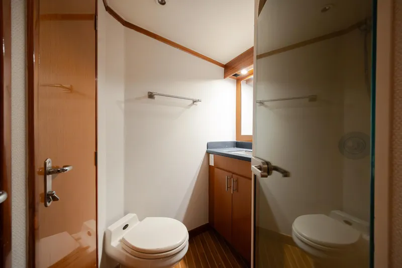Slide: The Image of Bathroom interior of 2000 Viking 55 Convertible yacht, featuring modern fixtures and wood accents. - 38