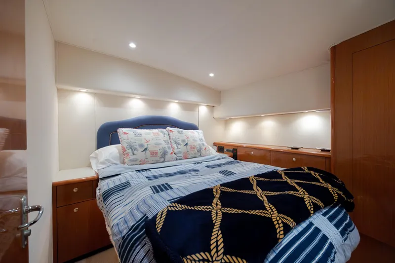 Slide: The Image of Luxurious bedroom interior of 2000 Viking 55 Convertible yacht with cozy bedding and ambient lighting. - 39