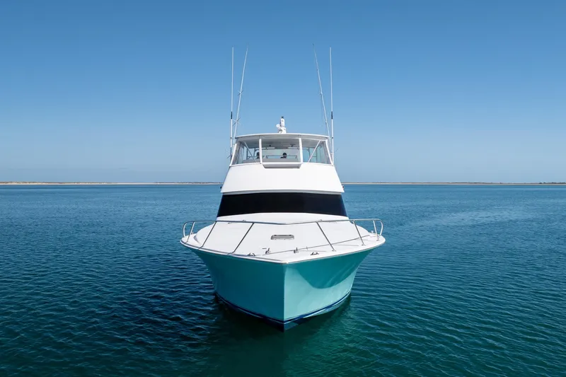 Slide: The Image of Front view of a 2000 Viking 55 Convertible yacht on calm blue waters. - 4