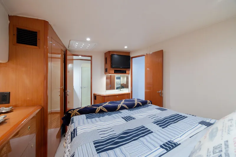 Slide: The Image of Interior of 2000 Viking 55 Convertible yacht bedroom with modern amenities and cozy decor. - 41