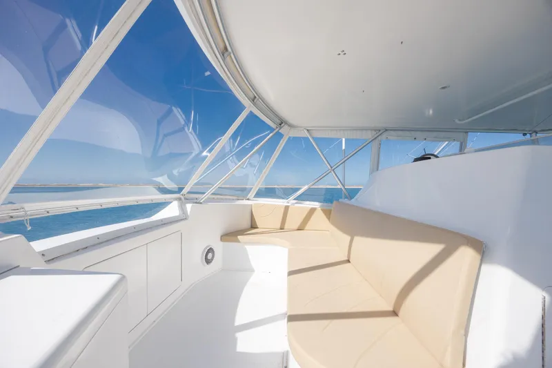 Slide: The Image of Interior view of a 2000 Viking 55 Convertible yacht with beige seating and ocean backdrop. - 70