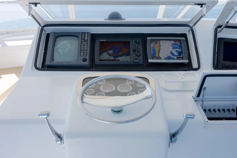 Slide: The Image of Control panel of a 2000 Viking 55 Convertible yacht with navigation screens and steering wheel. - 75