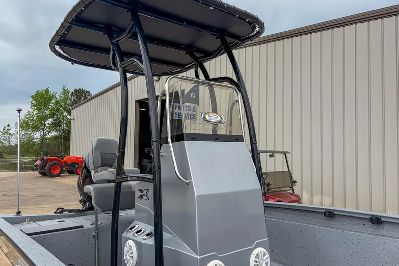 Slide: The Image of 2024 Xpress H190 boat with T-top, parked near service building. - 3