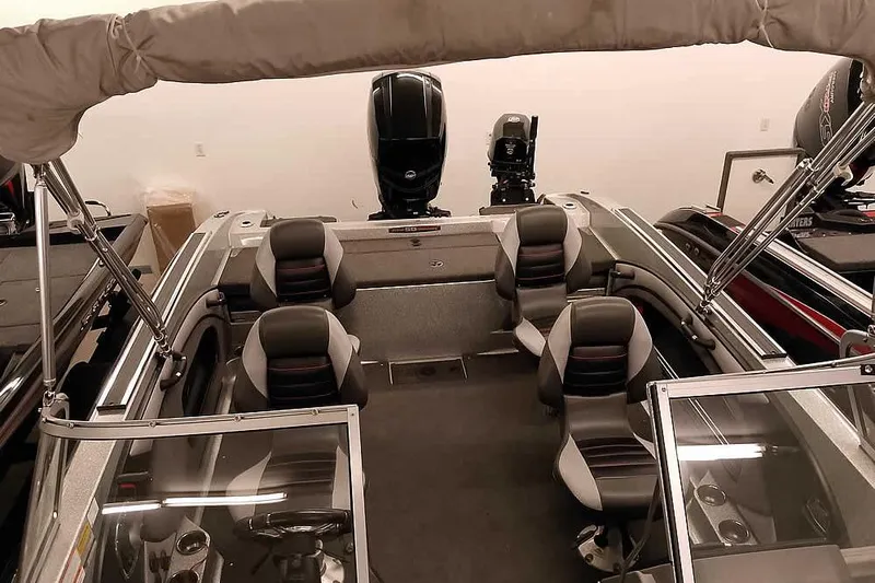 Slide: The Image of 2018 Ranger 1880MS Angler boat interior with seating and motor, in a showroom setting. - 30