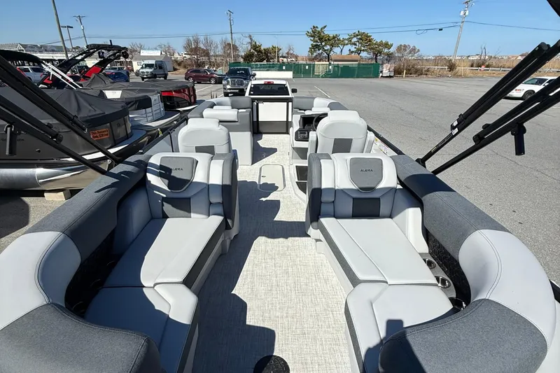Slide: The Image of 2026 Alera M23Q boat interior with spacious seating and modern design in a marina setting. - 11