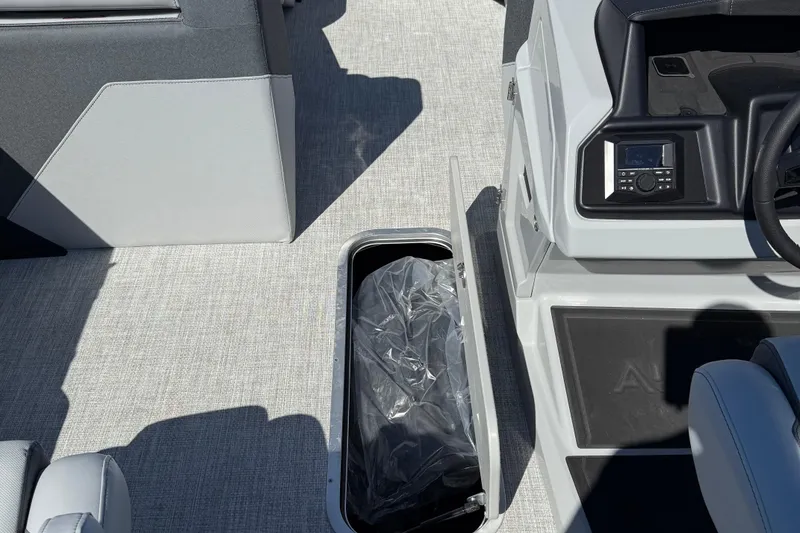 Slide: The Image of Interior of 2026 Alera M23Q boat showing storage compartment and control panel. - 16