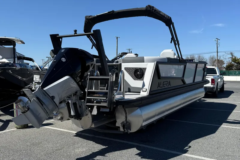 Slide: The Image of Alera M23Q 2026 pontoon boat with powerful outboard motor in a parking lot. - 8