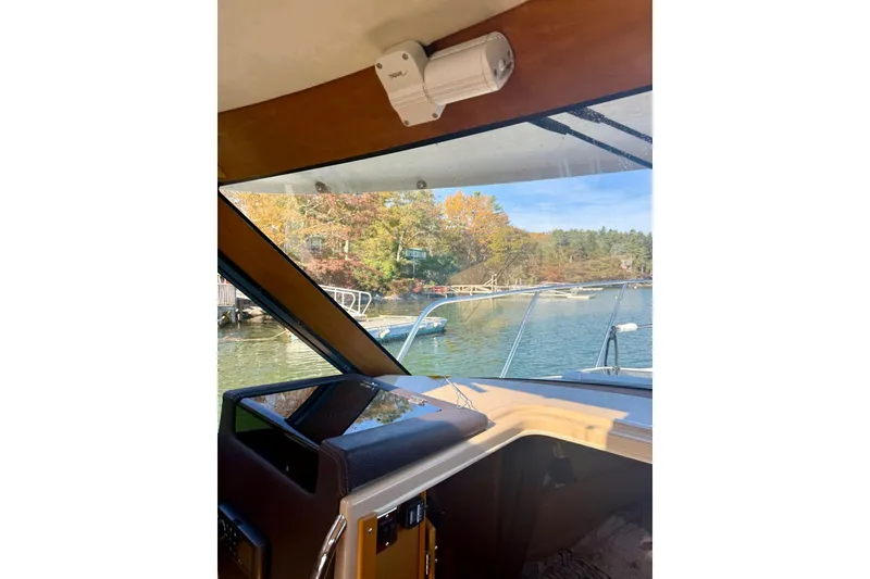 Slide: The Image of Interior view of 2014 Cutwater C-26 boat, overlooking serene lake and autumn foliage. - 11