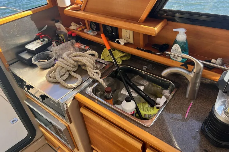 Slide: The Image of 2014 Cutwater C-26 boat interior with cluttered kitchen sink and countertop. - 13