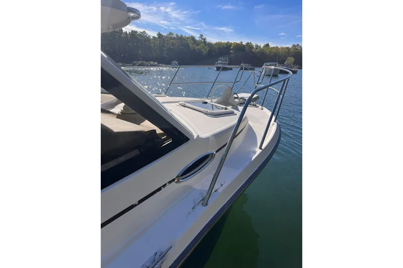 Slide: The Image of 2014 Cutwater C-26 boat on calm water, sunny day, forested shoreline in background. - 5