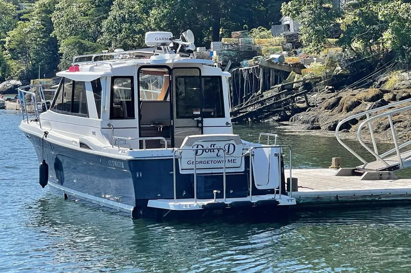 Slide: The Image of 2014 Cutwater C-26 boat docked in scenic harbor with lush greenery. - 8