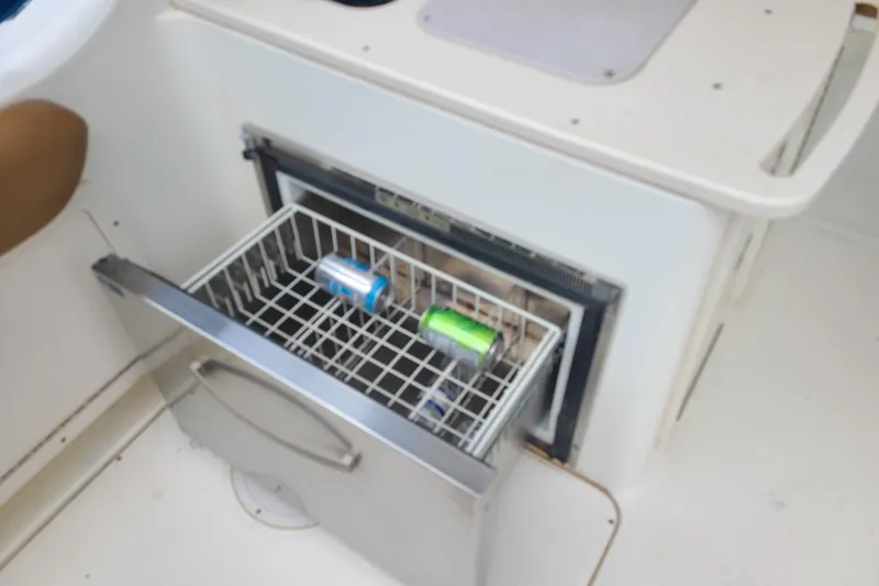 Slide: The Image of Built-in cooler drawer on 2010 World Cat 290 DC boat with beverages inside. - 13