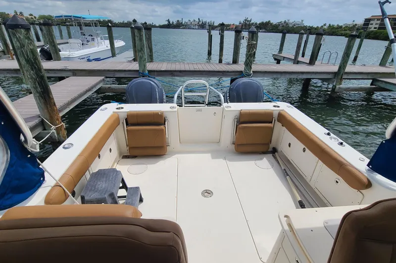 Slide: The Image of 2010 World Cat 290 DC boat interior at dock, featuring spacious seating and dual engines. - 19