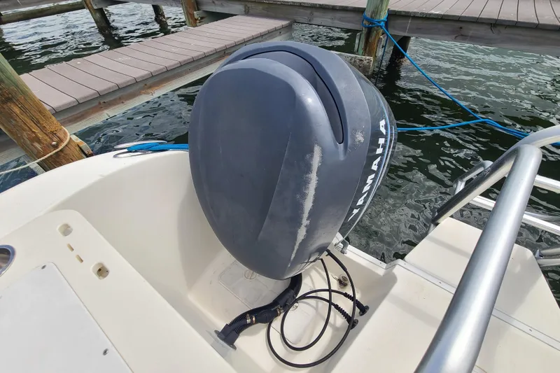 Slide: The Image of Outboard motor on a 2010 World Cat 290 DC boat docked by the water. - 21