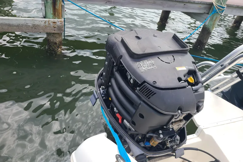 Slide: The Image of Outboard motor on a 2010 World Cat 290 DC boat docked by wooden pier. - 23