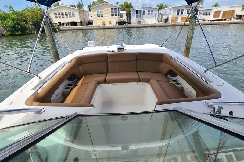 Slide: The Image of 2010 World Cat 290 DC boat with spacious seating, docked near waterfront homes. - 5