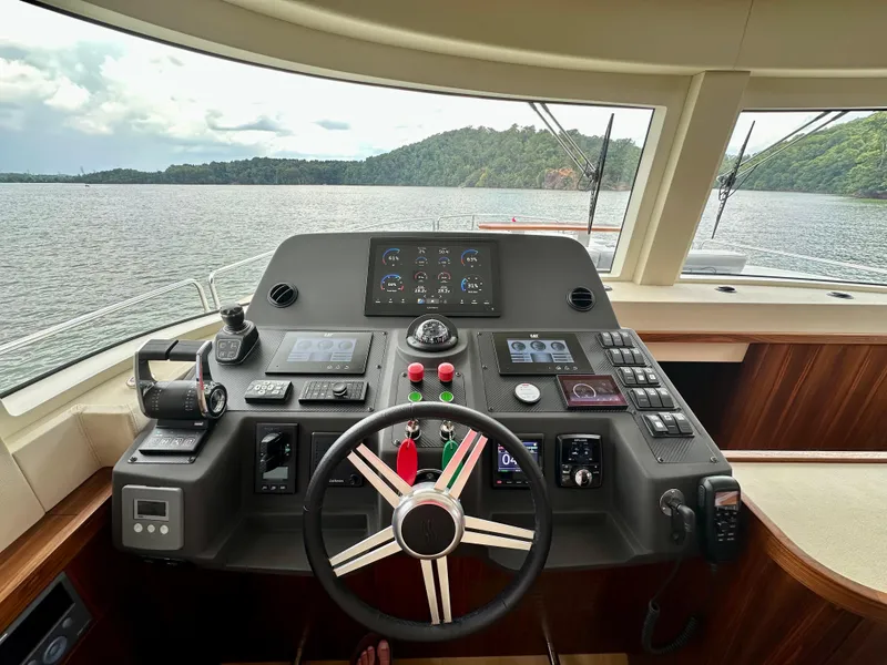 Slide: The Image of Helm station of 2021 Sirena 58 yacht with advanced navigation controls and scenic water view. - 36