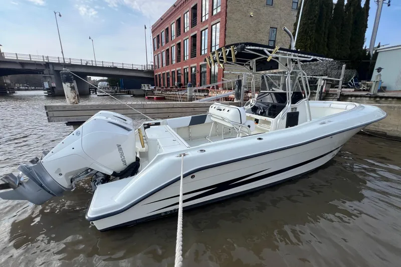Slide: The Image of 2001 Hydra-Sports Vector 2600 CC boat docked by a riverside building. - 2