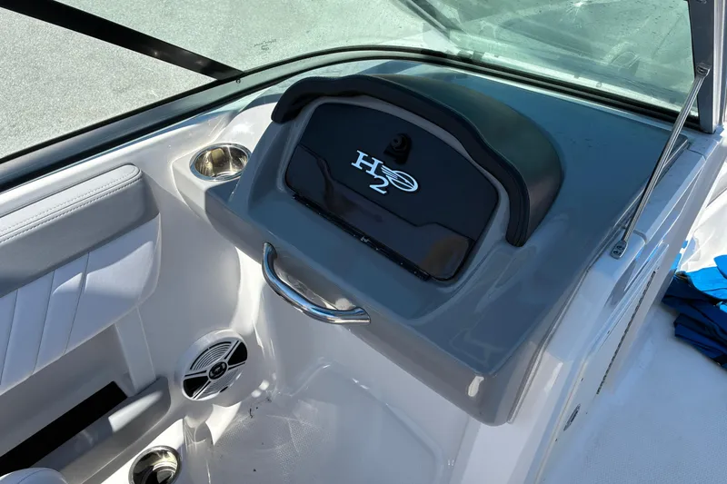 Slide: The Image of 2019 Chaparral 21 H2O Sport boat dashboard with cup holders and speaker. - 11