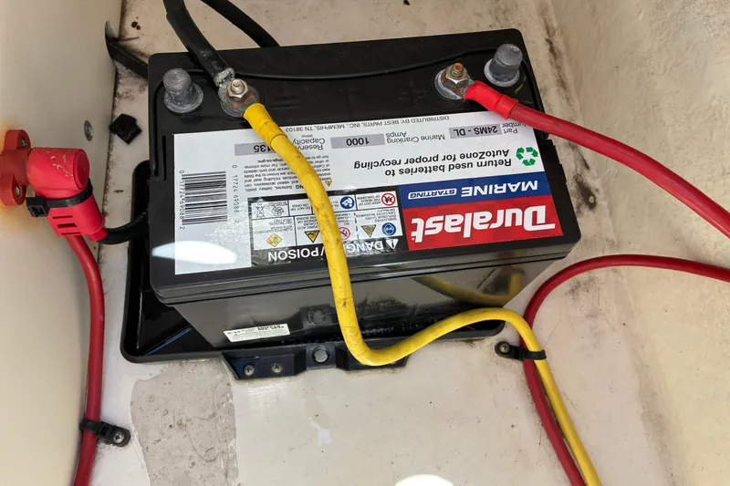 Slide: The Image of Marine battery in a 2019 Chaparral 21 H2O Sport boat, featuring red and yellow cables. - 16