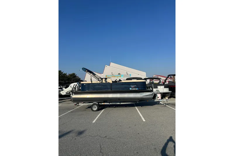 The Image of 2022 Sweetwater 2386 SB pontoon boat parked in a lot under clear blue sky. - 1