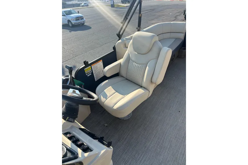 Slide: The Image of Luxurious seating in 2022 Sweetwater 2386 SB boat, featuring plush captain's chair and helm. - 10