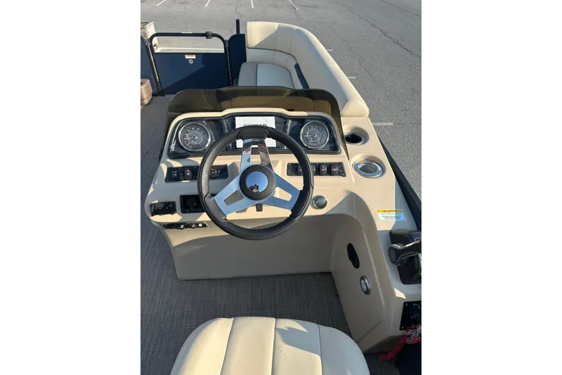 Slide: The Image of 2022 Sweetwater 2386 SB boat dashboard with steering wheel and gauges. - 11