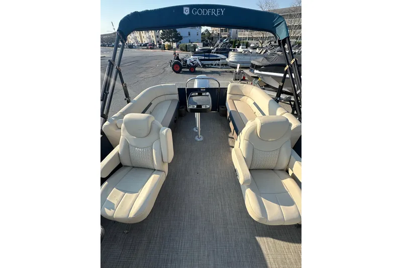 Slide: The Image of 2022 Sweetwater 2386 SB pontoon boat with beige seating and canopy in marina. - 13