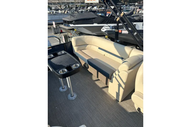 Slide: The Image of 2022 Sweetwater 2386 SB pontoon boat interior with beige seating and cup holders. - 15