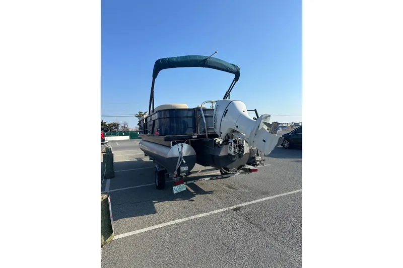 Slide: The Image of 2022 Sweetwater 2386 SB pontoon boat parked in a lot under clear blue sky. - 5