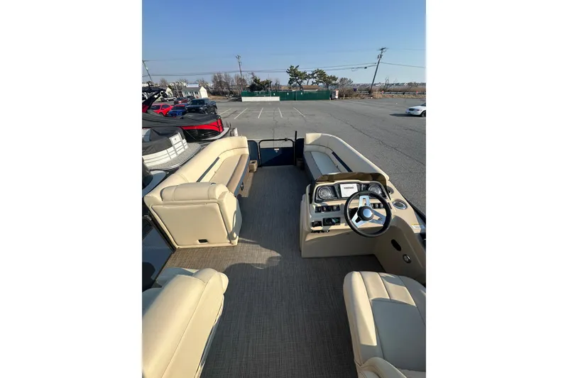 Slide: The Image of Interior view of 2022 Sweetwater 2386 SB pontoon boat with beige seating and steering console. - 8